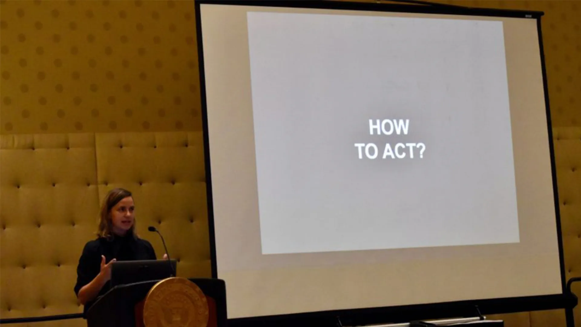Kate Orff presenting at US Senator Sheldon Whitehouse's ninth annual Rhode Island Energy, Environment, and Oceans Leaders Day with a presentation that states "How To Act".