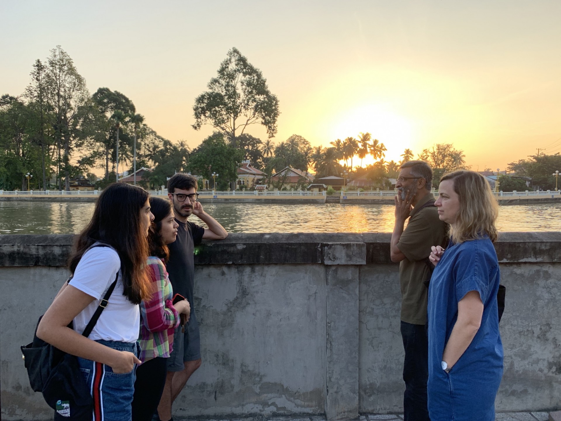 Professor Off and Dacunha talk to students in front of a Buddhist pagoda